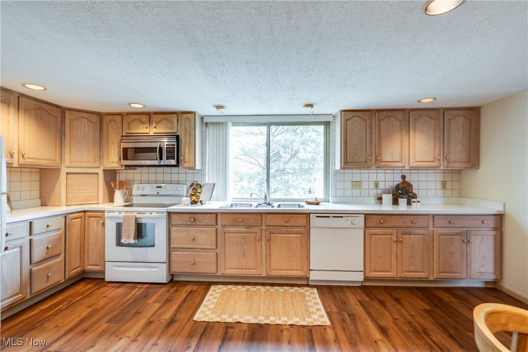 308 Guy's Run Road Akron, OH 44319 - Photo 21 of 44 Kitchen with backsplash, a textured ceiling, a sink, and white appliances