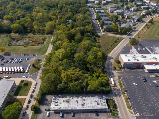 an aerial view of a house with a garden and lake view