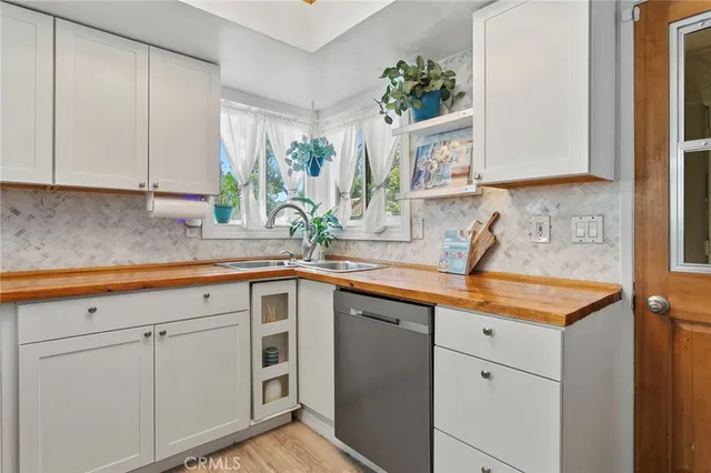 a kitchen with stainless steel appliances white cabinets and a sink