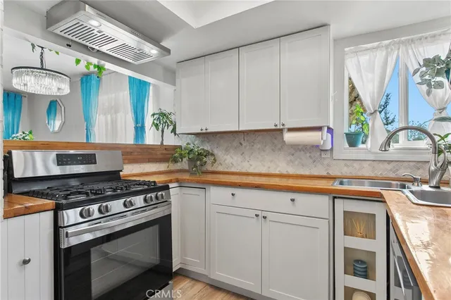 a kitchen with stainless steel appliances granite countertop a sink a stove and cabinets