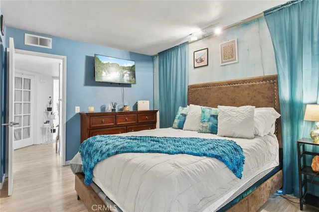 a bedroom with a bed and a lamp on dresser