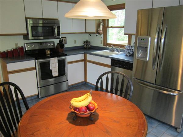 9 Halcyon Farm Road Lakeville, MA 02347 - Photo 5 of 13 a kitchen with stainless steel appliances a dining table a refrigerator a stove a microwave a dining table and chairs