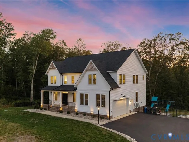 a view of a white house with a big yard and large trees