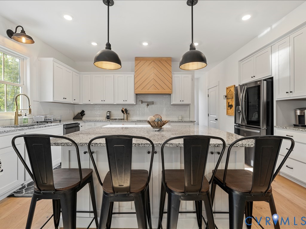 4021 Tredon Road Mechanicsville, VA 23111 - Photo 15 of 50 a kitchen with stainless steel appliances granite countertop a dining table chairs and a refrigerator