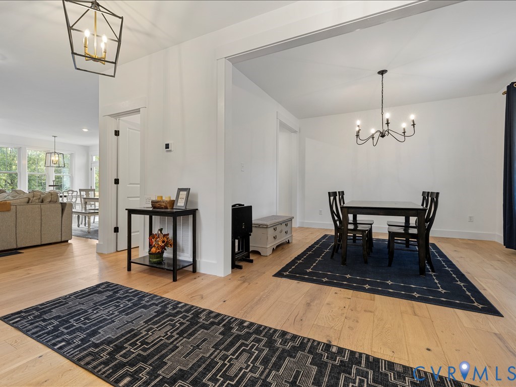 4021 Tredon Road Mechanicsville, VA 23111 - Photo 7 of 50 a dining room with wooden floor a chandelier a wooden table and chairs