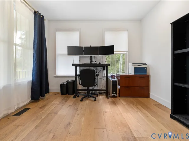 a living room with furniture and a dining table with wooden floor