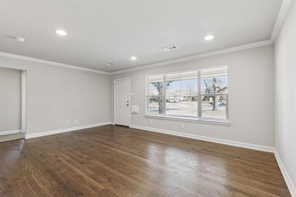 9363 Angora Street Dallas, TX 75218 - Photo 2 of 10 an empty room with wooden floor and windows