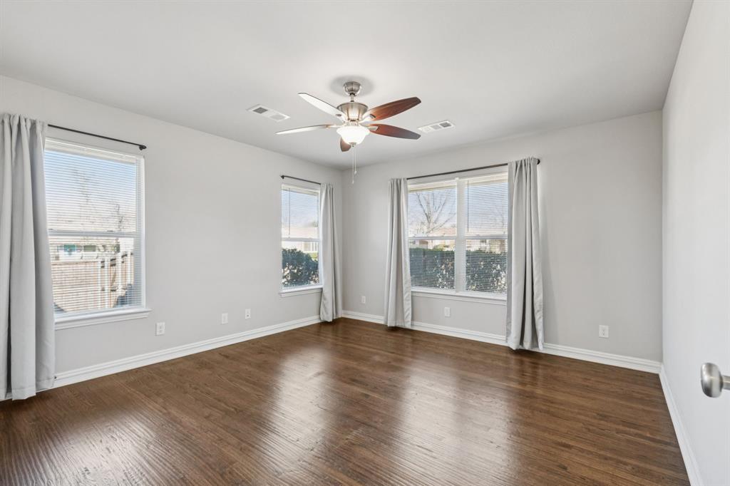 9363 Angora Street Dallas, TX 75218 - Photo 5 of 10 a view of an empty room with wooden floor and a window