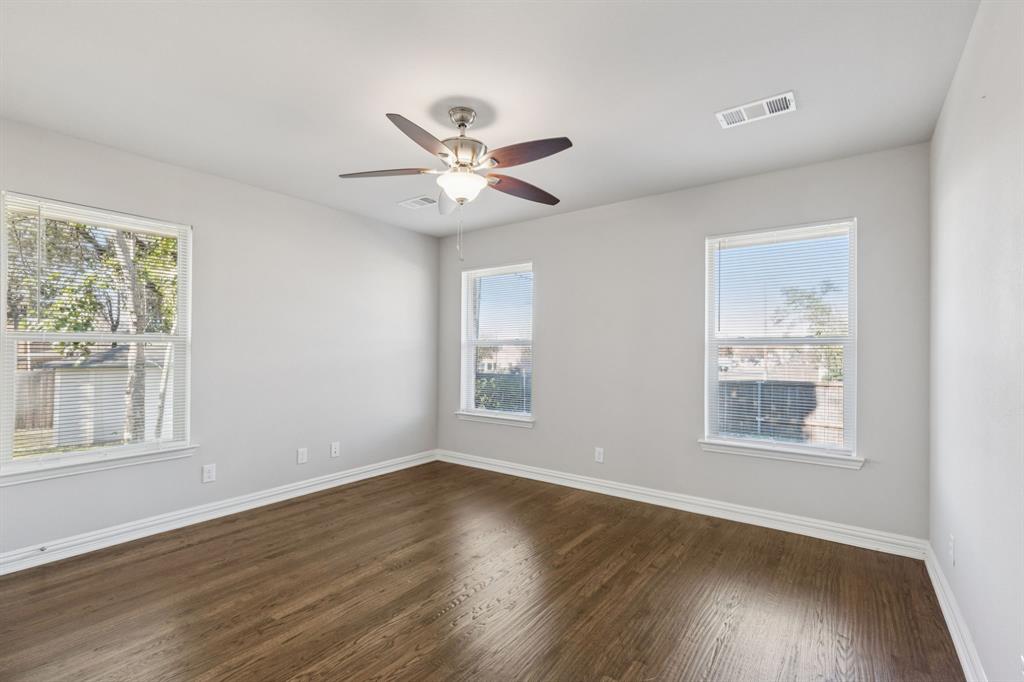 9363 Angora Street Dallas, TX 75218 - Photo 7 of 10 a view of an empty room with wooden floor and a window
