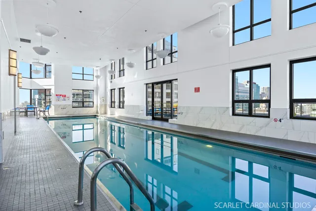 a kitchen with stainless steel appliances granite countertop a dining table chairs cabinets and a sink