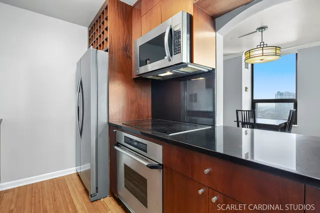 a kitchen with stainless steel appliances granite countertop a sink a stove and refrigerator