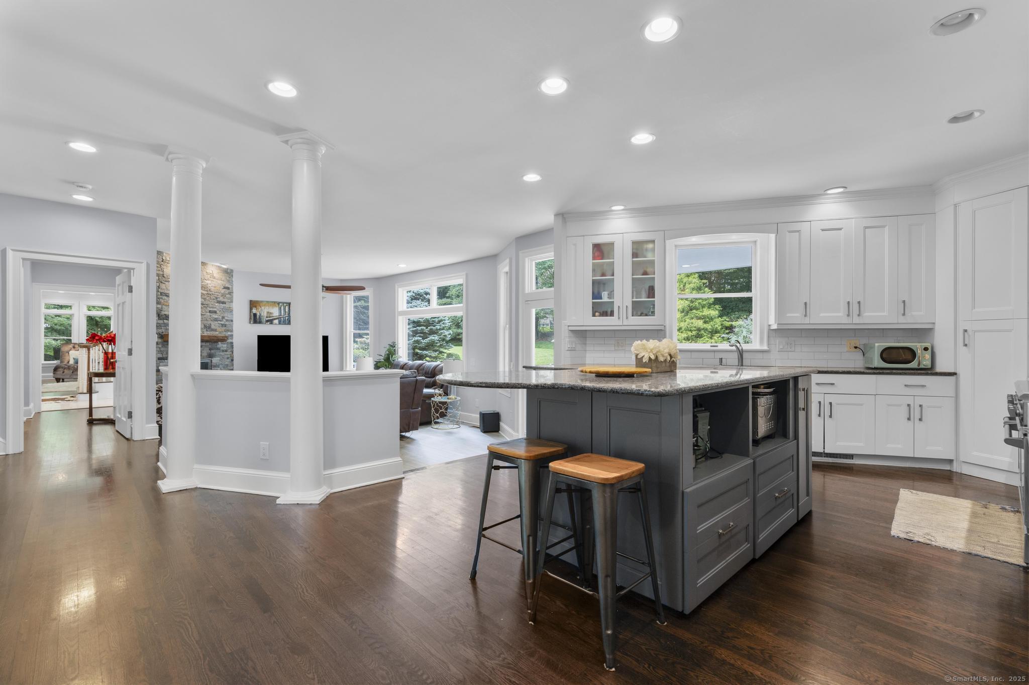 101 Brambly Hedge Circle Fairfield, CT 06824 - Photo 14 of 40 a kitchen with a table chairs a sink dishwasher a refrigerator and cabinets with wooden floor