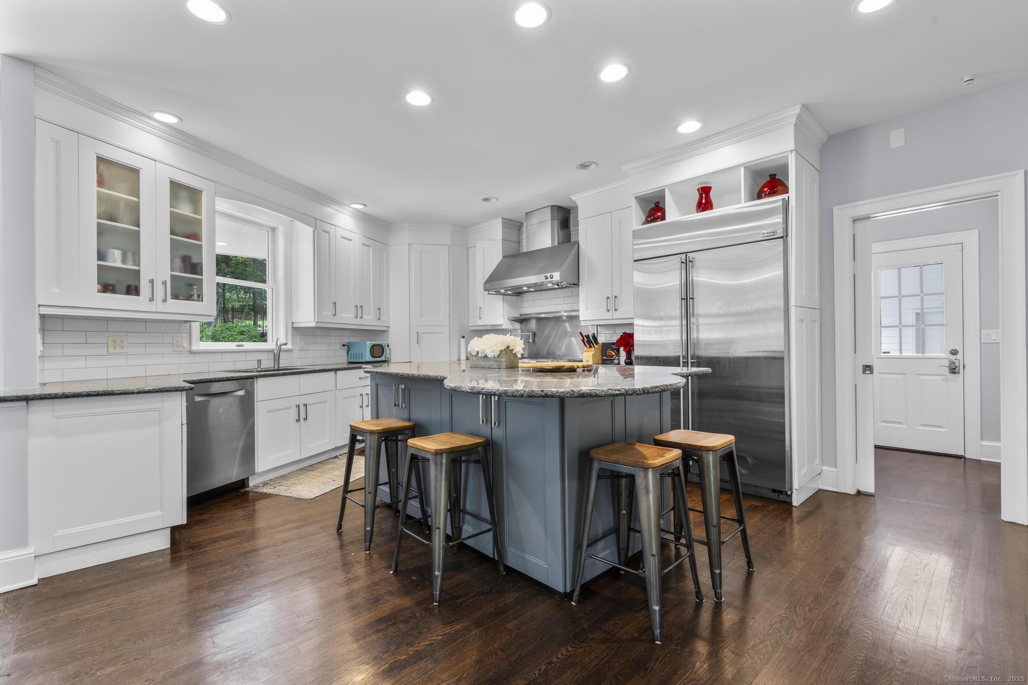 101 Brambly Hedge Circle Fairfield, CT 06824 - Photo 15 of 40 a kitchen with stainless steel appliances granite countertop wooden floors refrigerator and dining table