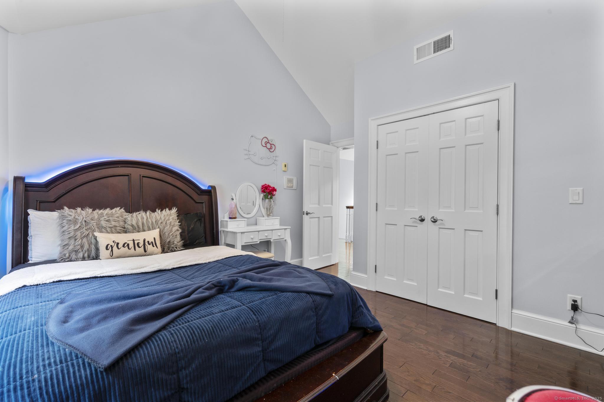 101 Brambly Hedge Circle Fairfield, CT 06824 - Photo 25 of 40 a bedroom with a bed a mirror and a potted plant