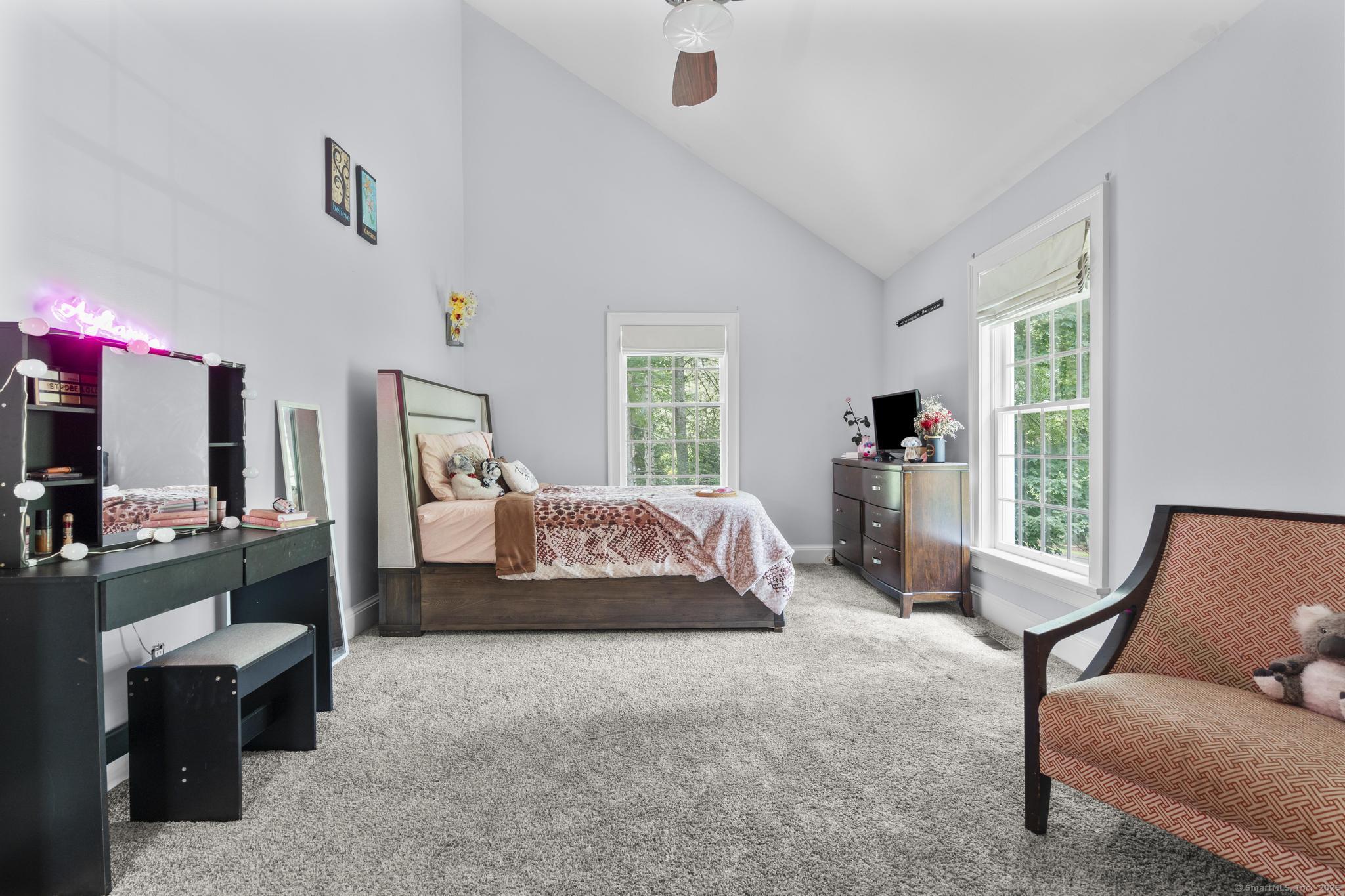 101 Brambly Hedge Circle Fairfield, CT 06824 - Photo 34 of 40 a spacious bedroom with a bed a couch and a window