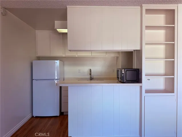 a kitchen with a sink a refrigerator and cabinets