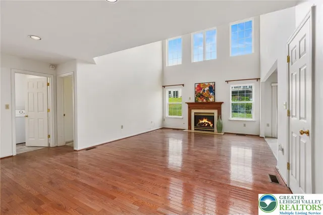 a view of a livingroom with wooden floor a fireplace and window