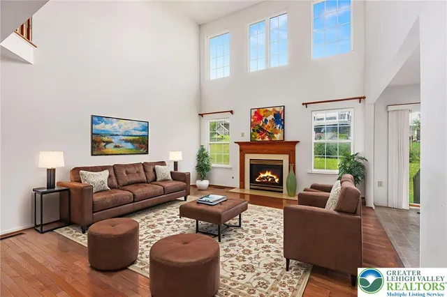 a living room with furniture fireplace and a large window