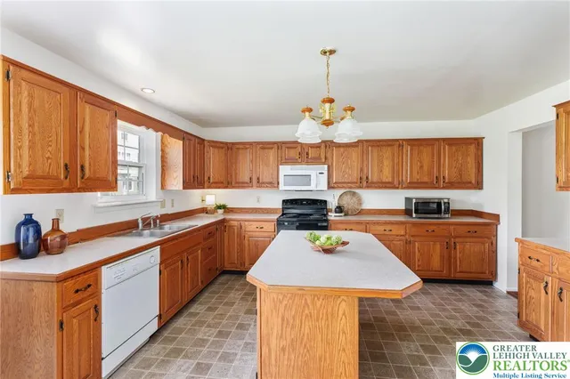 a kitchen with a sink a counter space appliances and cabinets