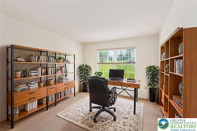 a view of a workspace with furniture and a window