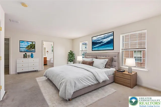 a spacious bedroom with a bed a couch and a window