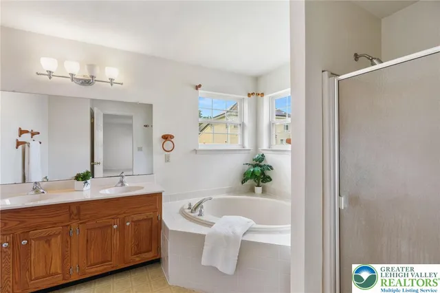 a spacious bathroom with a tub shower and mirror