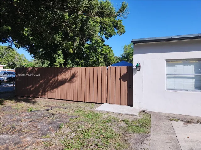 a view of backyard with small cabin and wooden fence