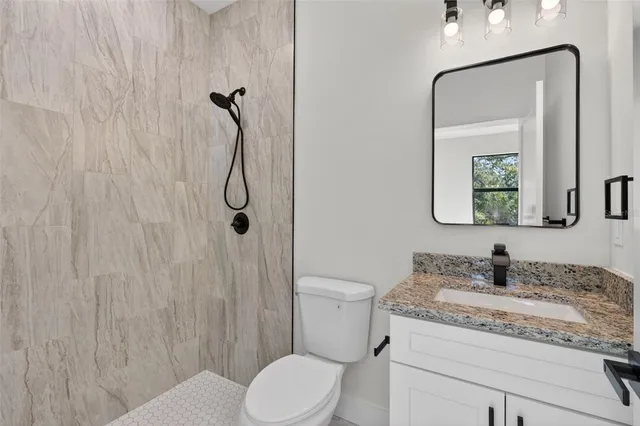 a bathroom with a granite countertop sink toilet and shower