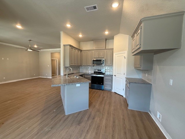 1031 South Anderson Street Angleton, TX 77515 - Photo 3 of 20 a kitchen with stainless steel appliances granite countertop a refrigerator a sink dishwasher a stove and white countertops with wooden floor