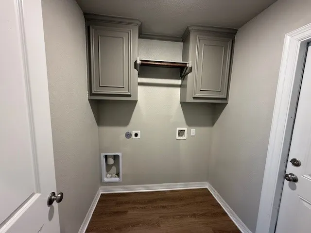 an empty room with wooden floor and cabinet