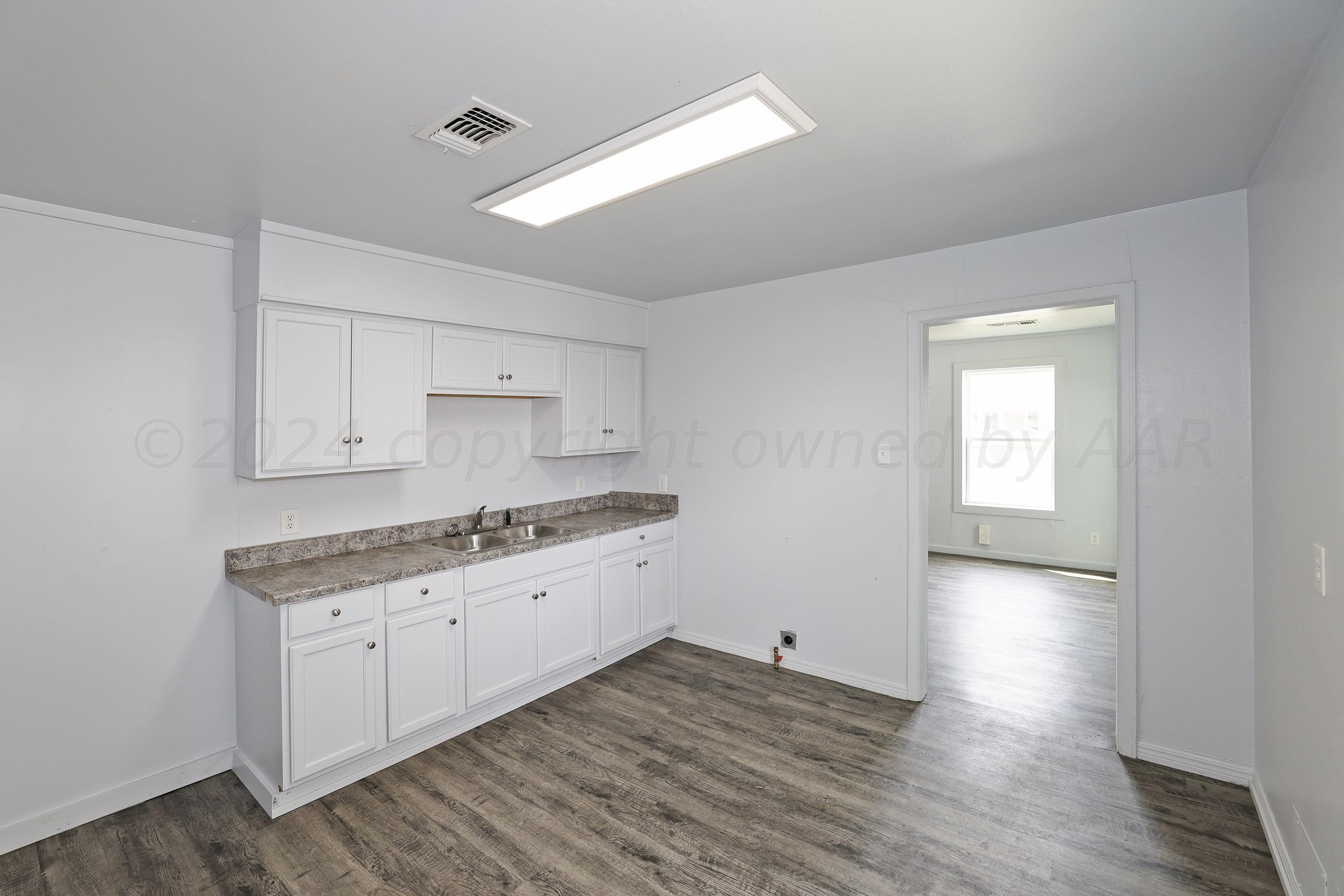 3703 South Monroe Street Amarillo, TX 79110 - Photo 8 of 14 a kitchen with granite countertop a sink and a stove top oven