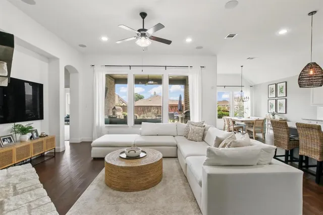 a kitchen with stainless steel appliances granite countertop a sink a stove a dining table and chairs with wooden floor