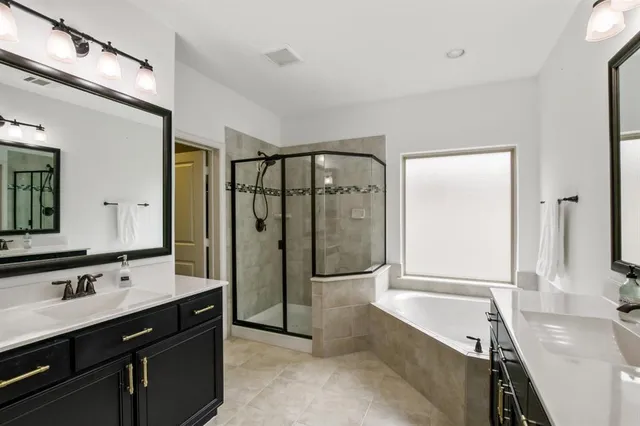 a bathroom with a tub sink and mirror