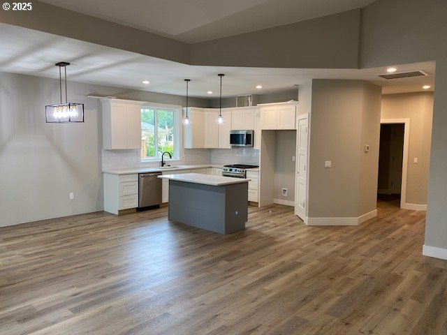 11645 Sawgrass Place Nehalem, OR 97131 - Photo 6 of 40 a kitchen with stainless steel appliances granite countertop a refrigerator a sink dishwasher a stove and white countertops with wooden floor