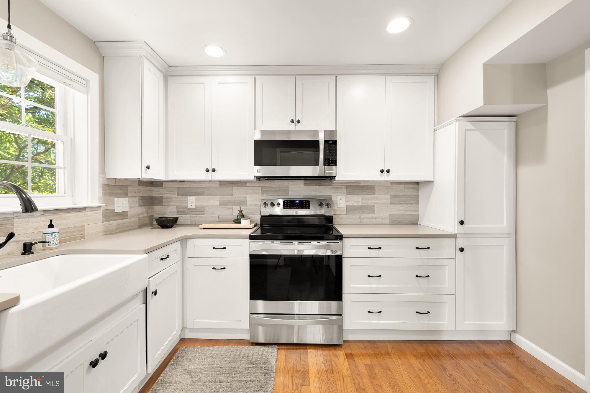 6723 Fairfax Road, Unit 15 Chevy Chase, MD 20815 - Photo 14 of 43 a kitchen with cabinets stainless steel appliances and a window