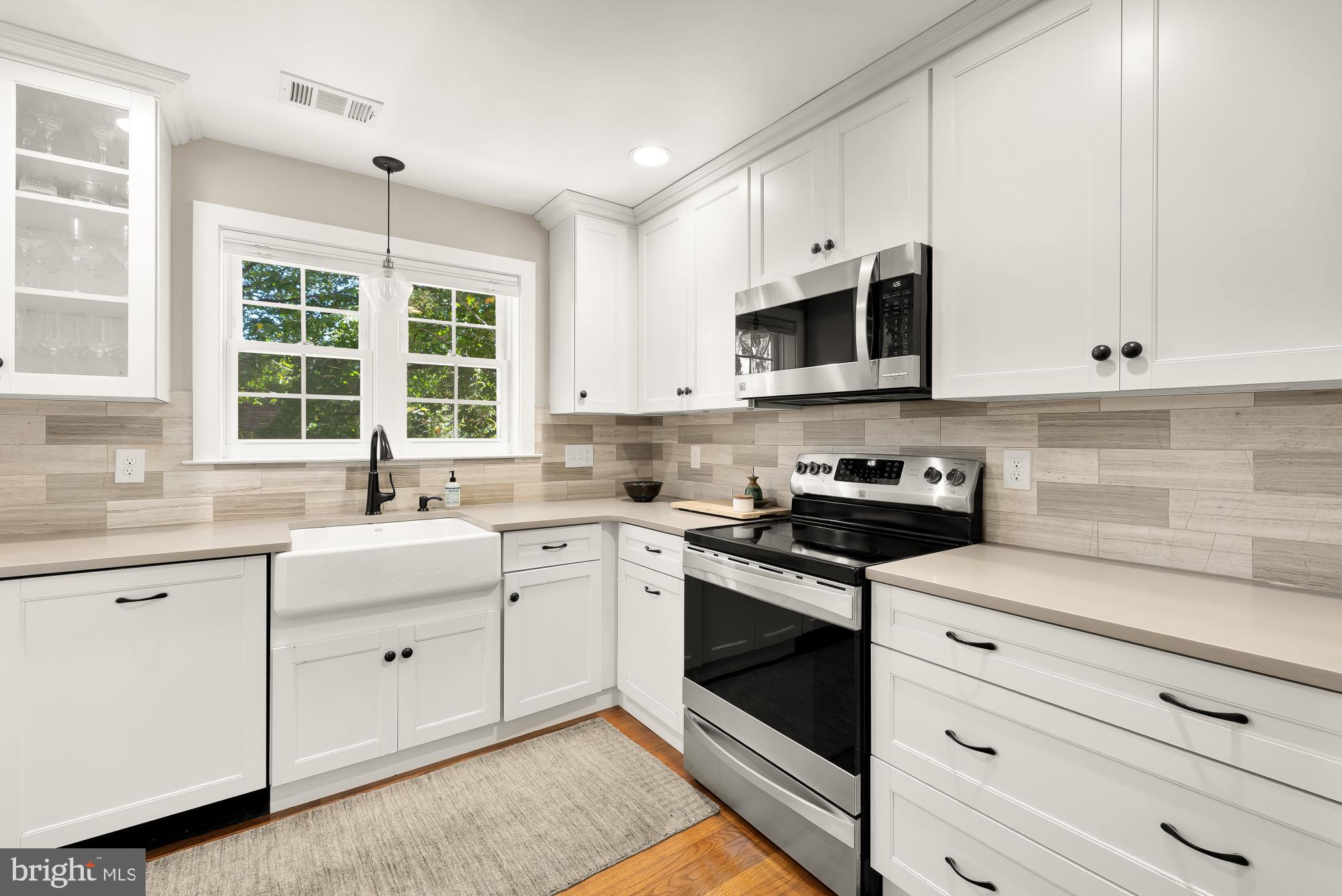 6723 Fairfax Road, Unit 15 Chevy Chase, MD 20815 - Photo 15 of 43 a kitchen with granite countertop white cabinets and window