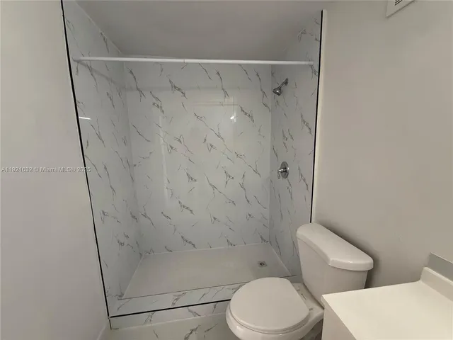 a white toilet and shower curtain