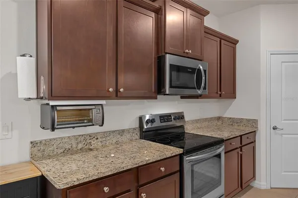 a kitchen with granite countertop cabinets stainless steel appliances and a counter space