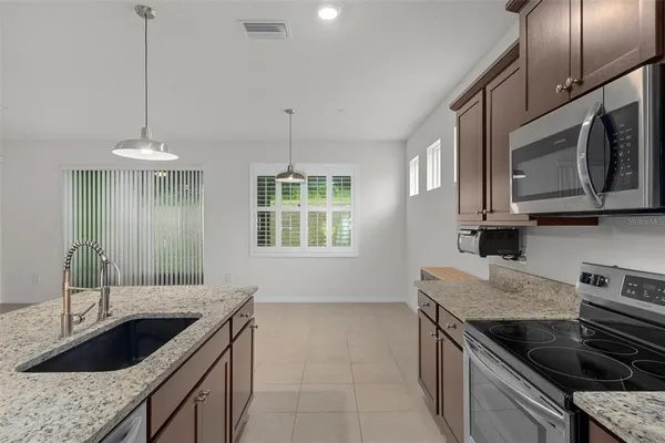 a kitchen with stainless steel appliances granite countertop a sink stove and microwave