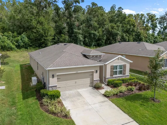 a aerial view of a house next to a yard