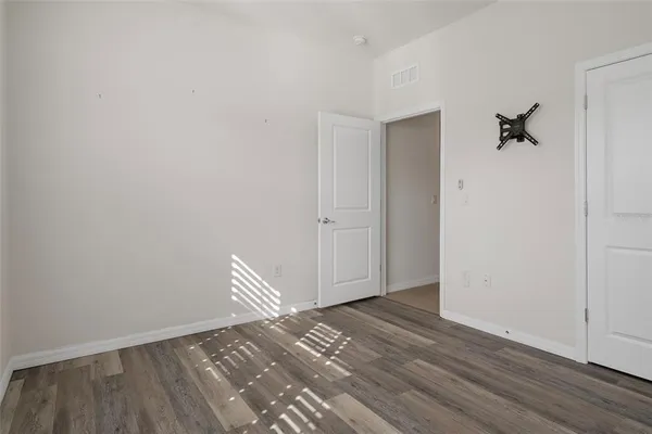 a view of room with wooden floor and closet