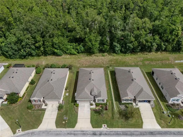 an aerial view of residential houses with outdoor space and parking
