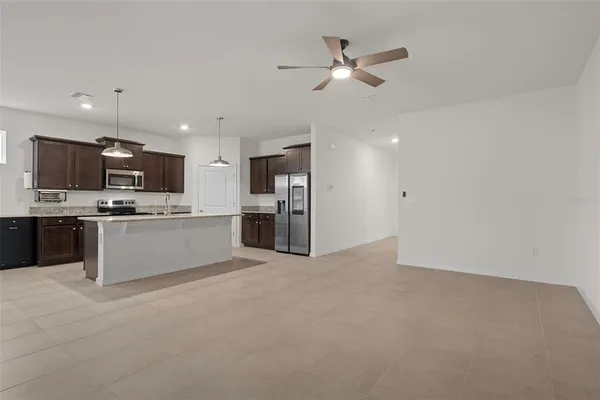 a view of kitchen with stainless steel appliances kitchen island a refrigerator sink and cabinets
