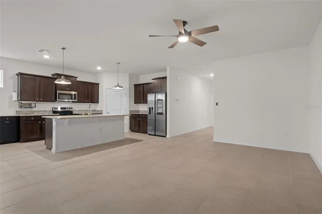 a view of kitchen with stainless steel appliances kitchen island a refrigerator sink and cabinets