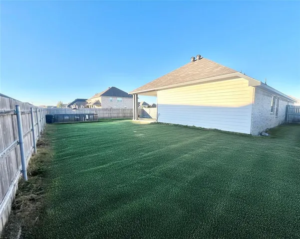 a backyard of a house with table and chairs