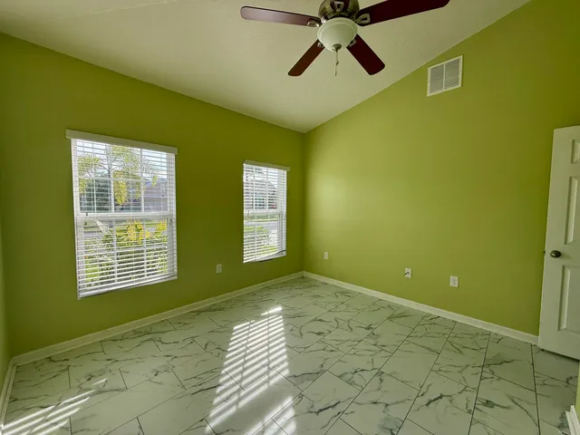 a view of an empty room with a window and a fireplace