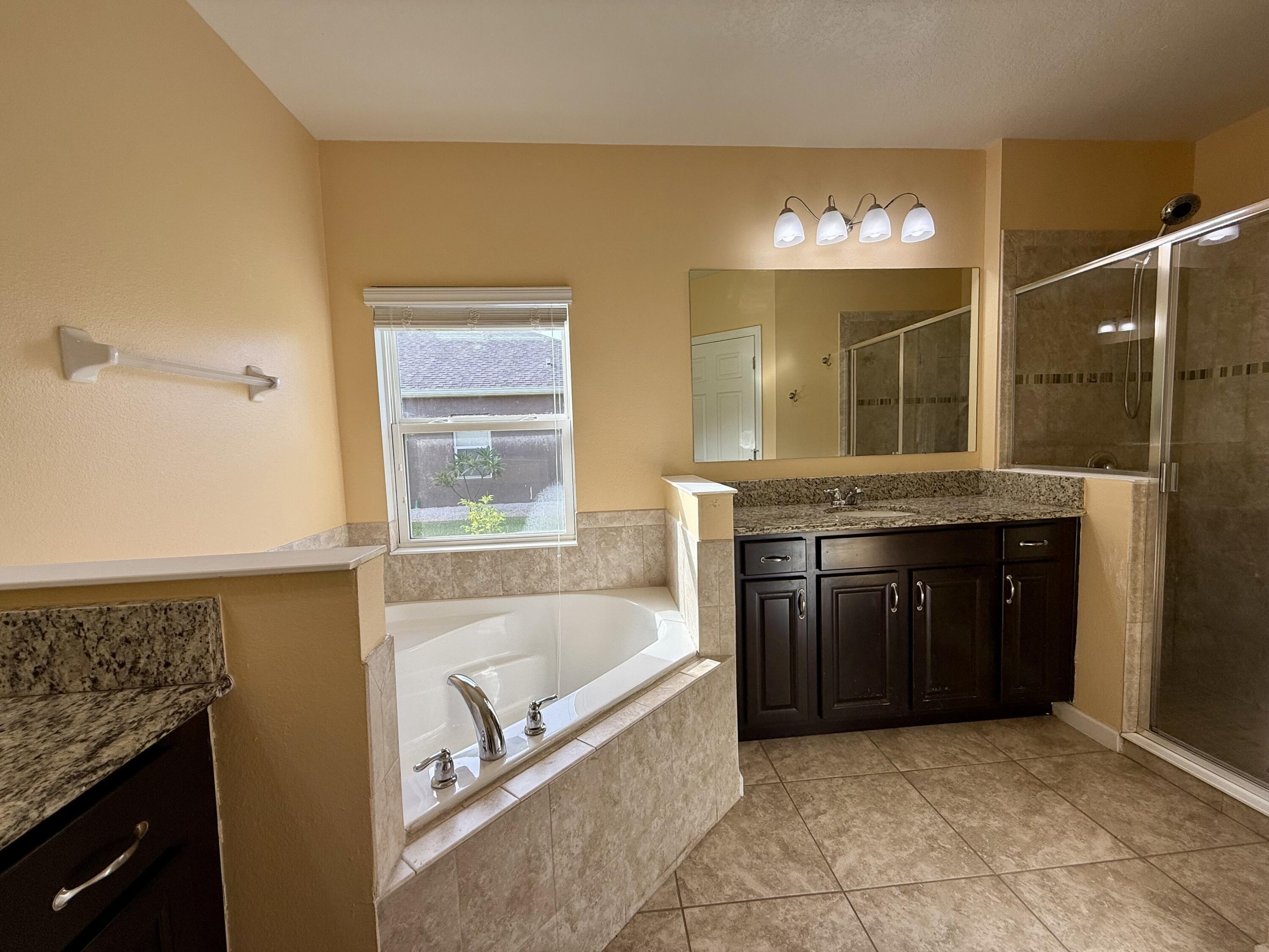 5997 Ridge Lake Circle Vero Beach, FL 32967 - Photo 10 of 14 a bathroom with a tub sink and mirror
