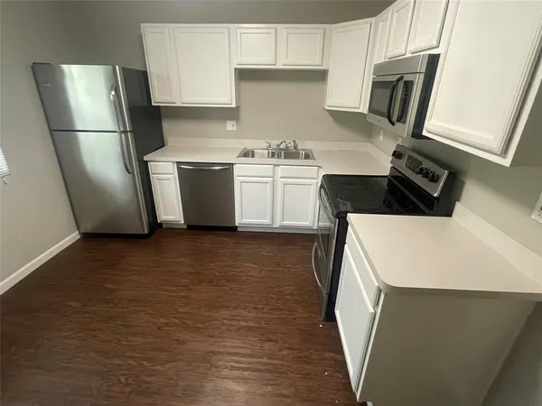 a kitchen with a sink a refrigerator and cabinets