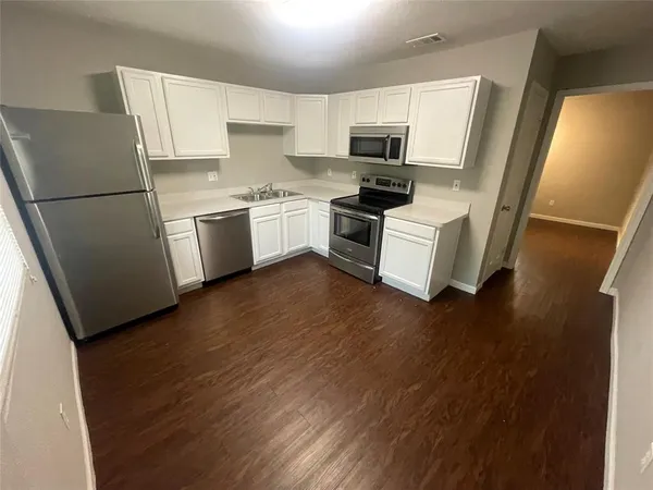 a kitchen with white cabinets and white appliances