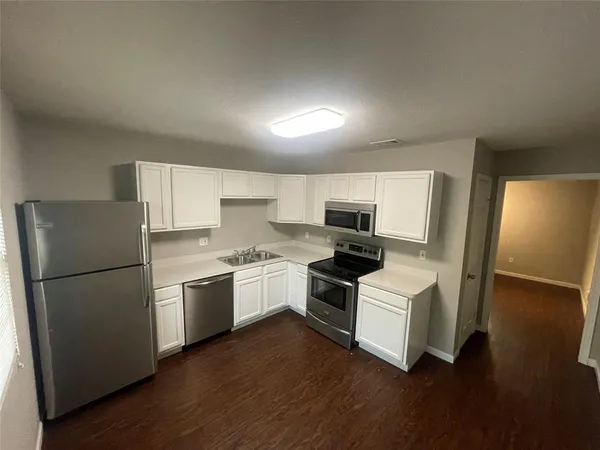 a kitchen with a refrigerator a stove a microwave and wooden floor